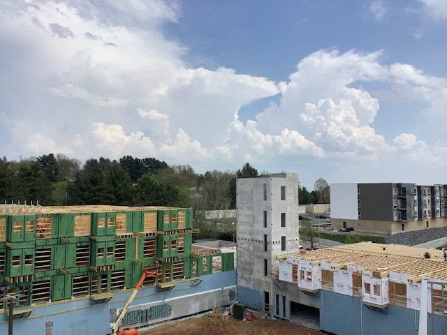 Construction site with partially built buildings under a cloudy sky.