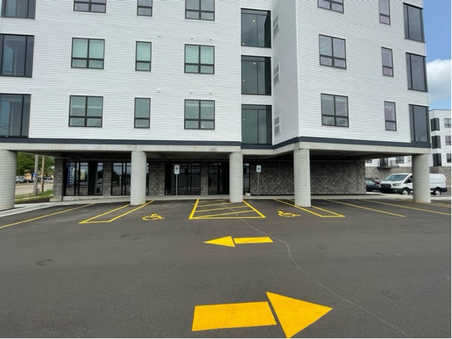 Building with accessible parking spaces, arrows, and pillars.