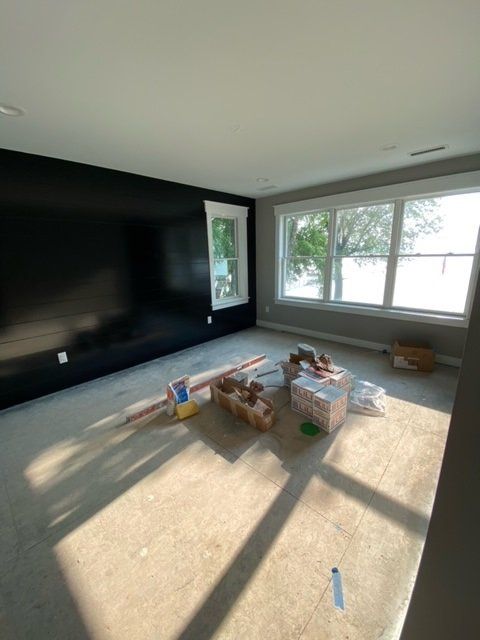 Room under construction with a black accent wall and a window.