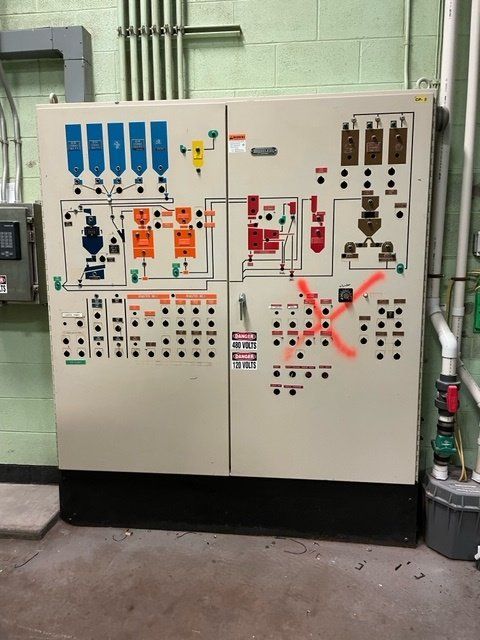Electrical control panel with detailed diagrams and buttons on a beige panel.