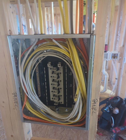 Electrical panel with numerous wires during construction.