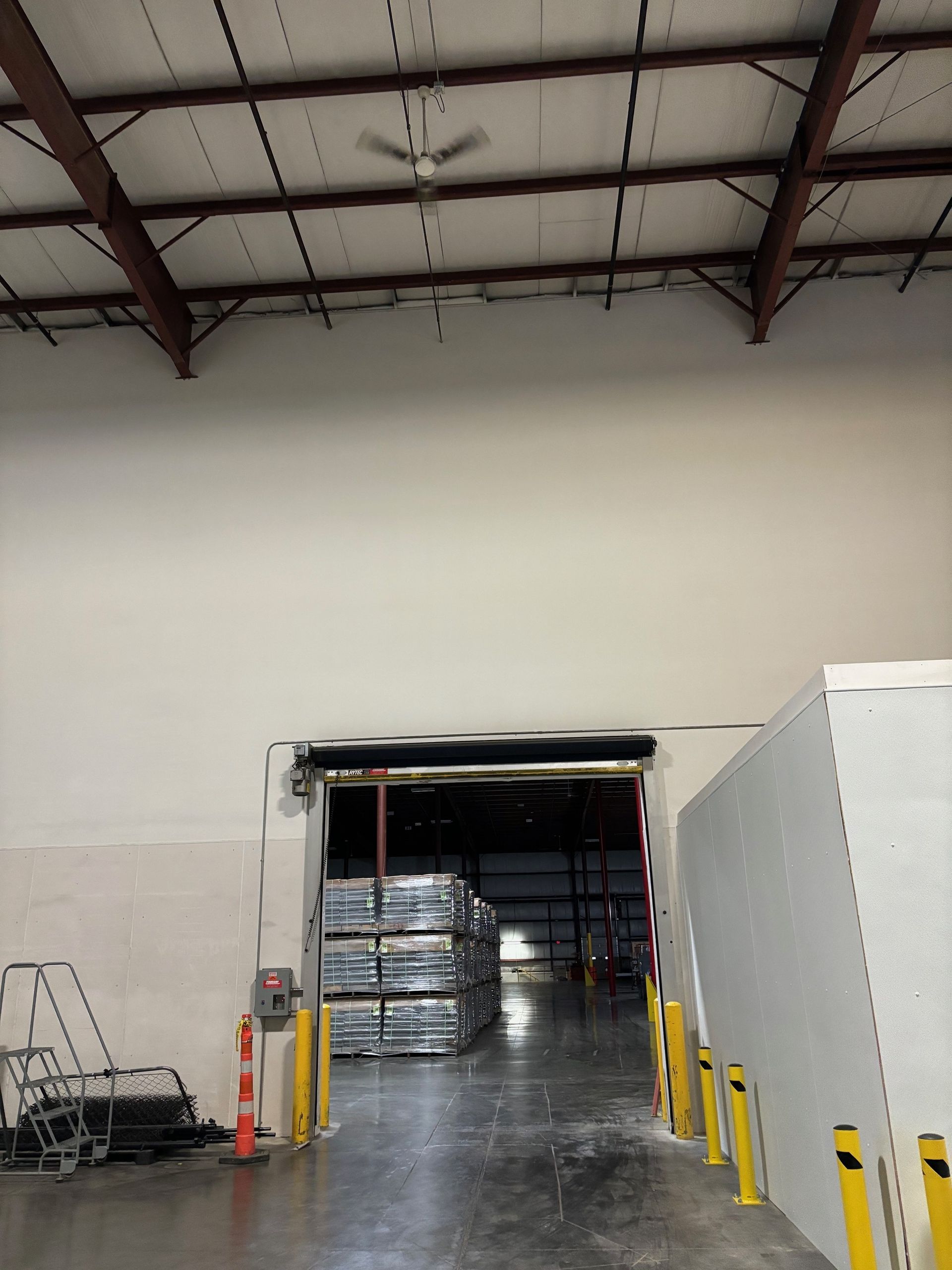 Interior warehouse view of loading dock with stacks of materials inside.
