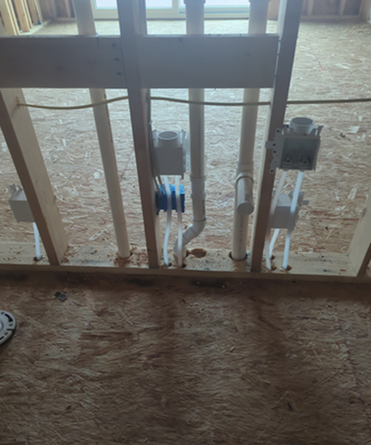 Framing with electrical boxes and plumbing in a new construction bathroom.