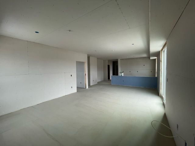 Empty room under construction with drywall and concrete floor.