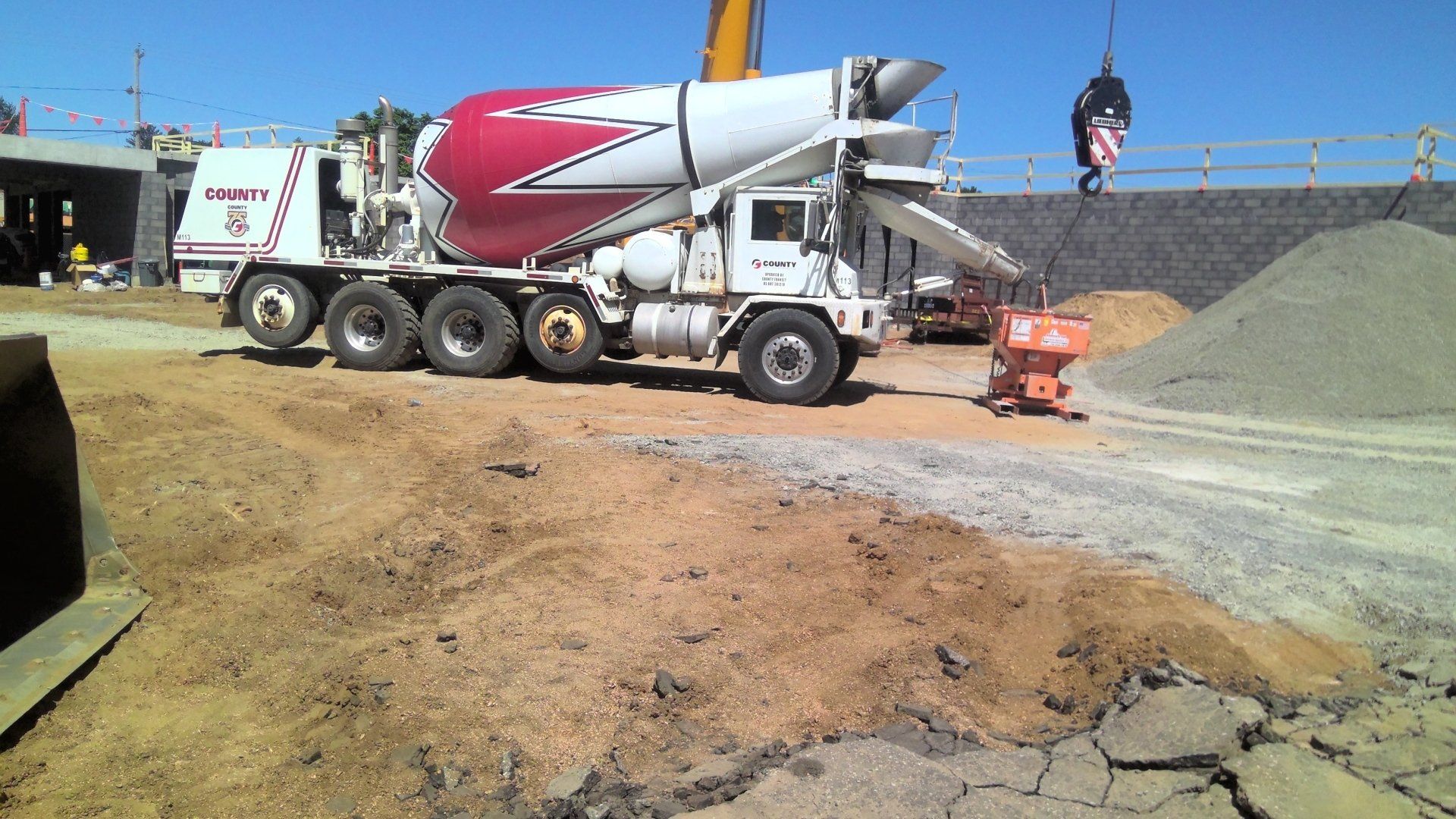 Cement truck at a construction site, pouring concrete.