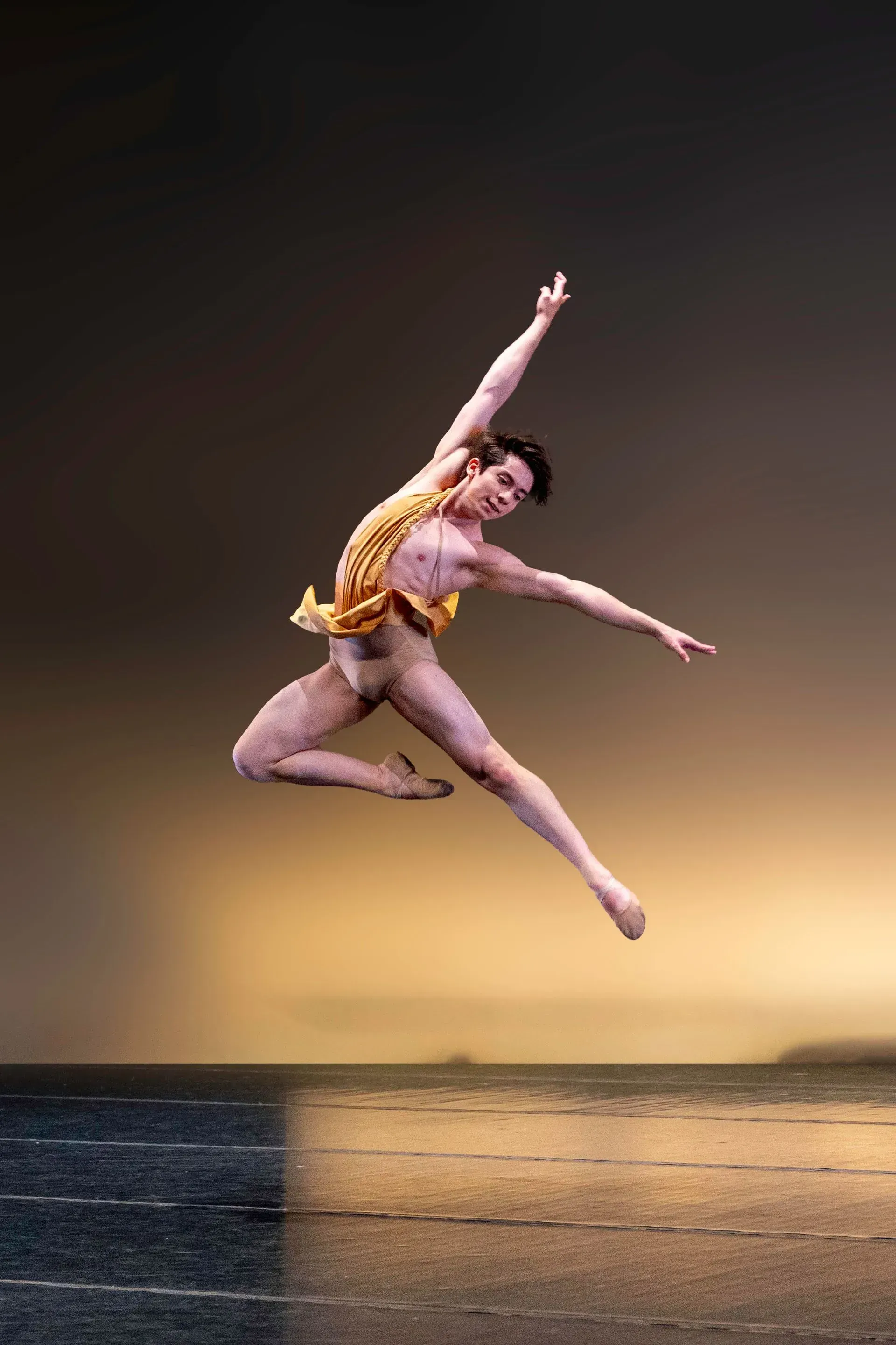A man is jumping in the air on a stage.