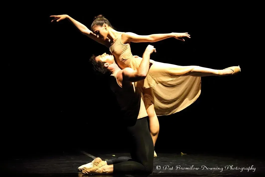 A man is holding a woman in his arms on a stage