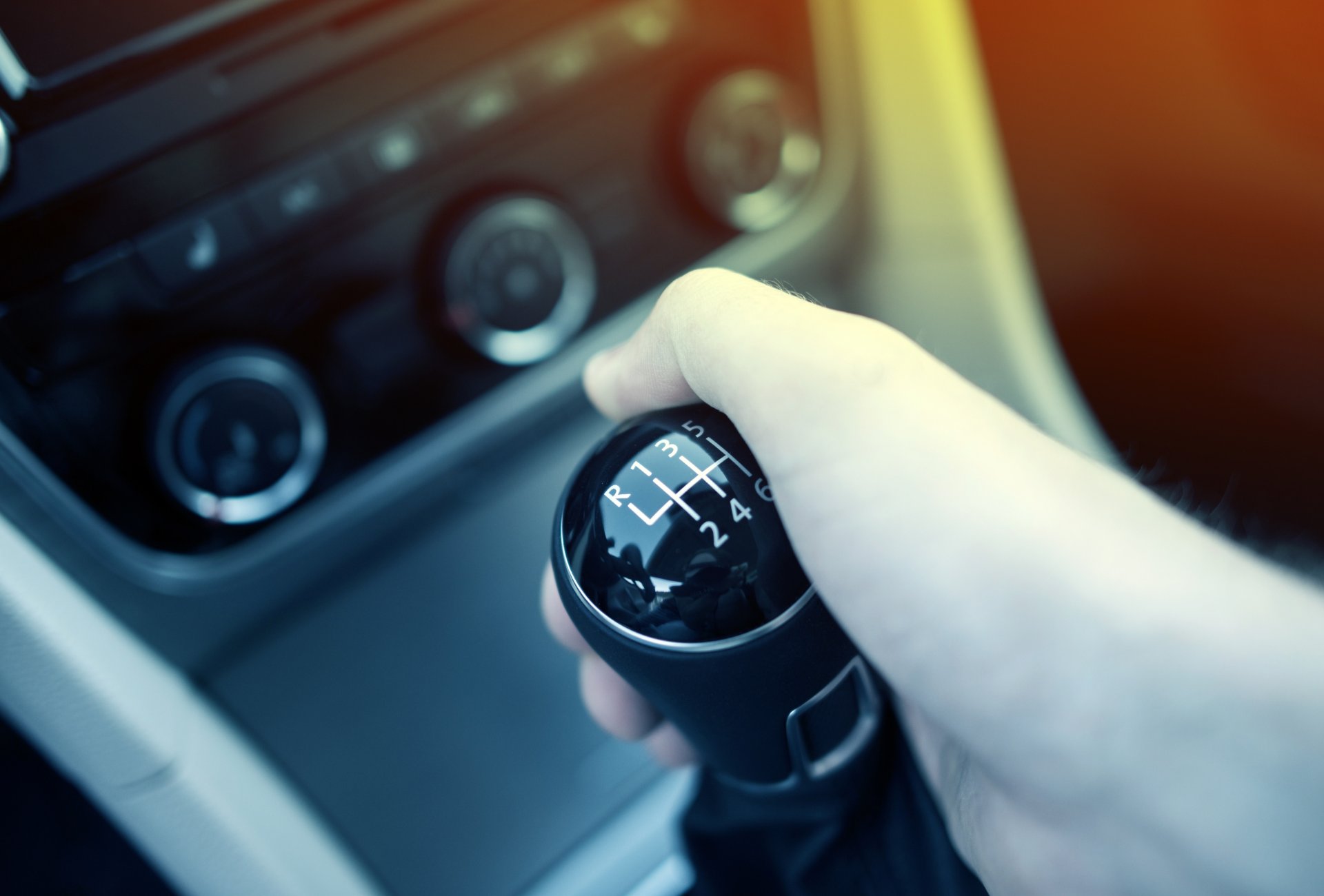 A person is holding a car shifter in their hand.