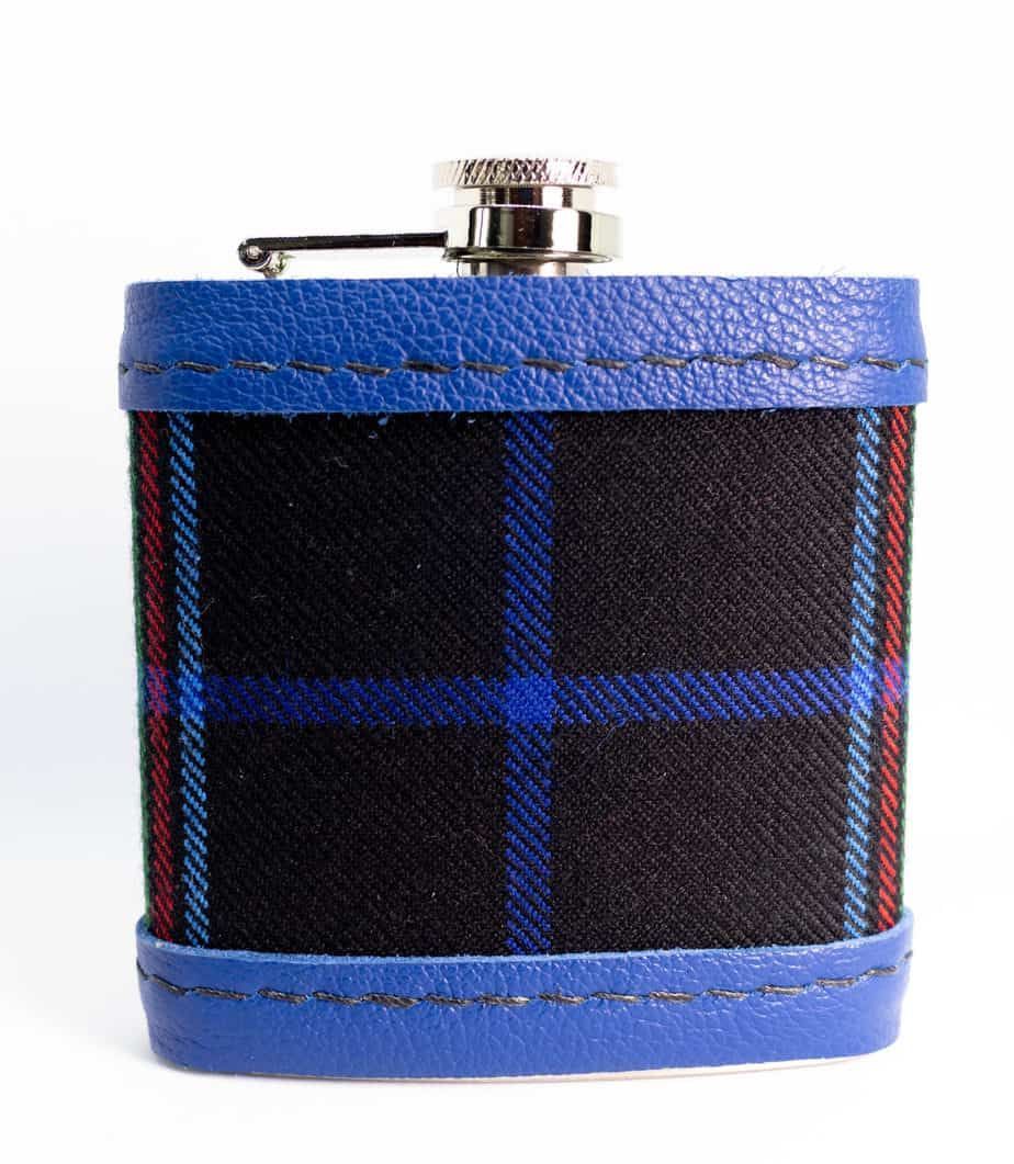 Flask with black and blue plaid center, green leather top and bottom, and a silver cap.