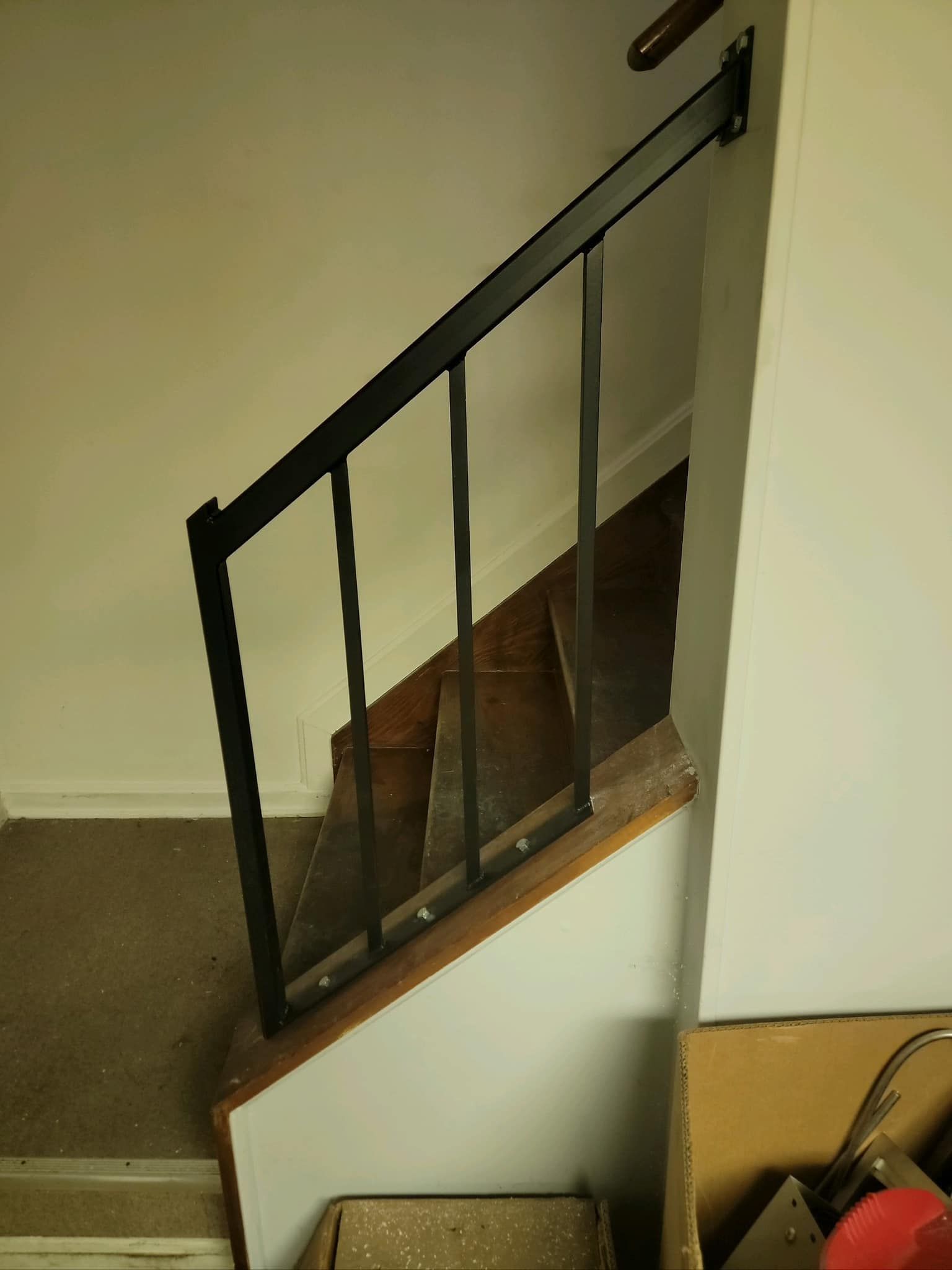 A staircase with a black railing and wooden steps