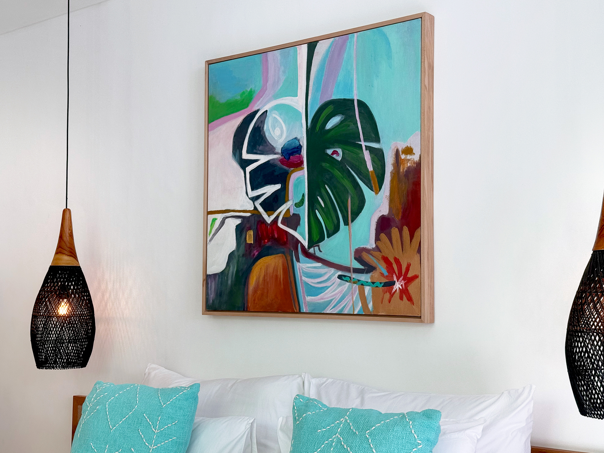 Modern bedroom with turquoise pillows, hanging black lamps, and colorful abstract wall art above the bed