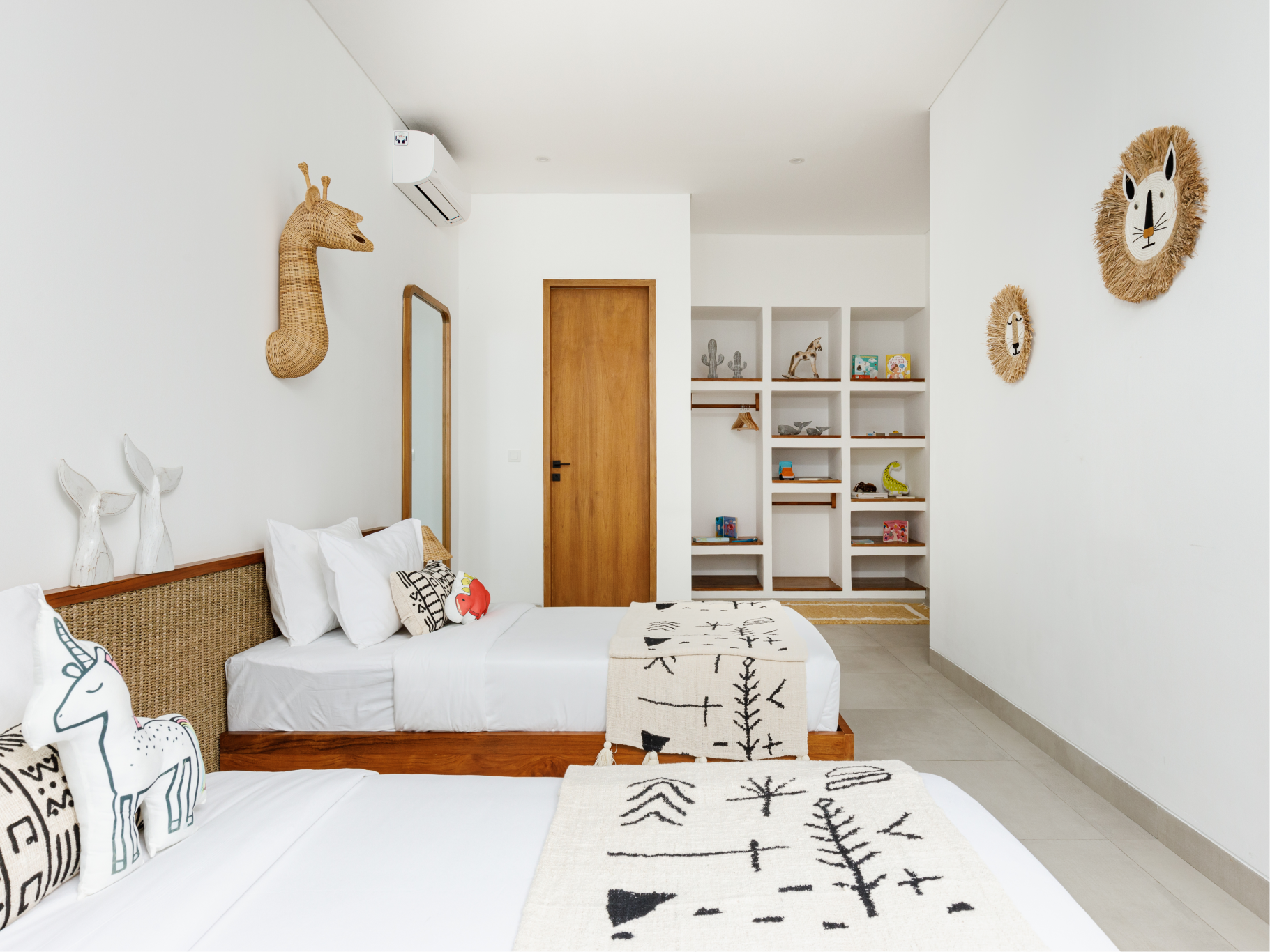 Bright white bedroom with wicker bed, patterned rug, shelves, and woven wall decor