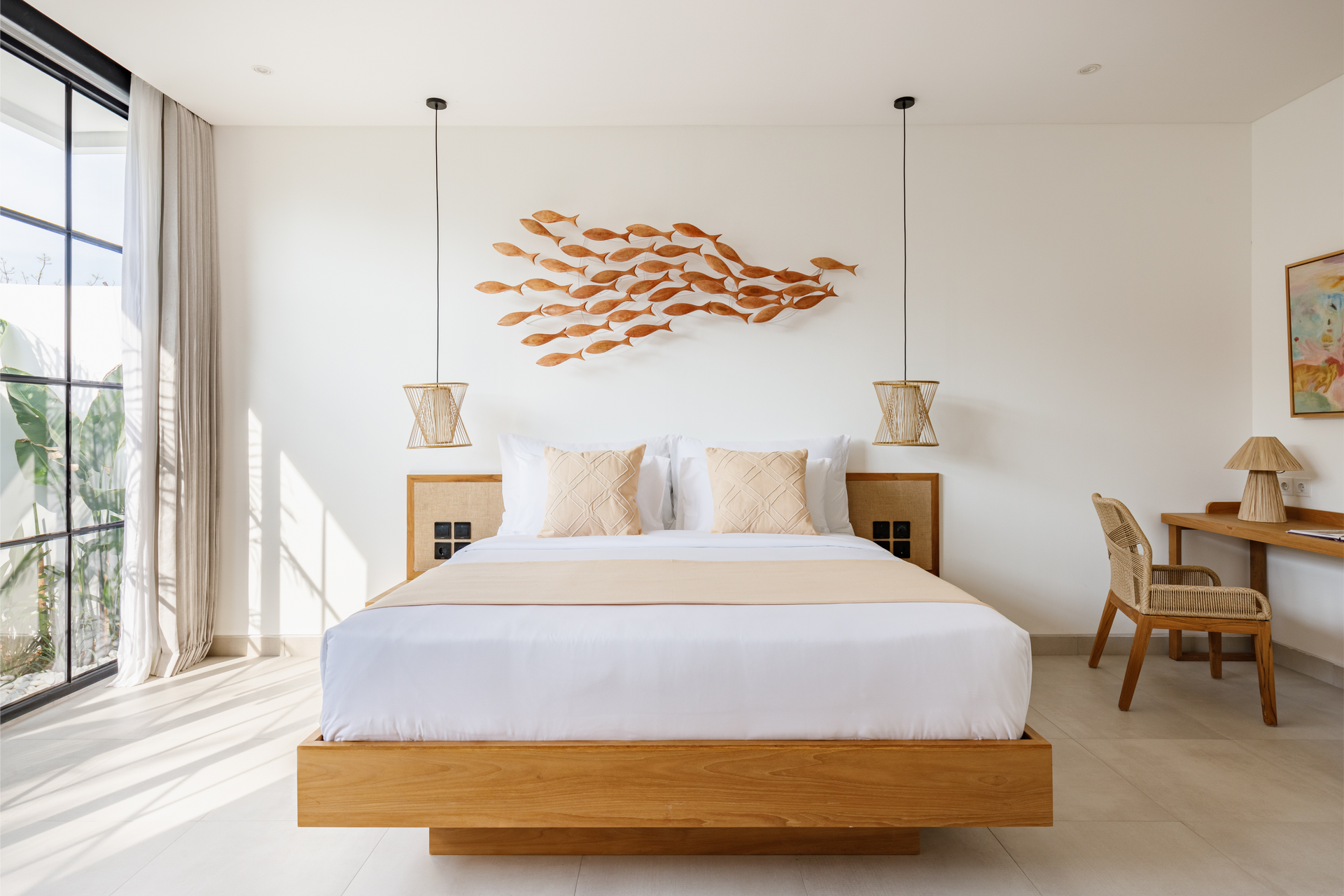 Bright minimalist bedroom with a wooden bed, wall art, pendant lights, and sliding glass doors