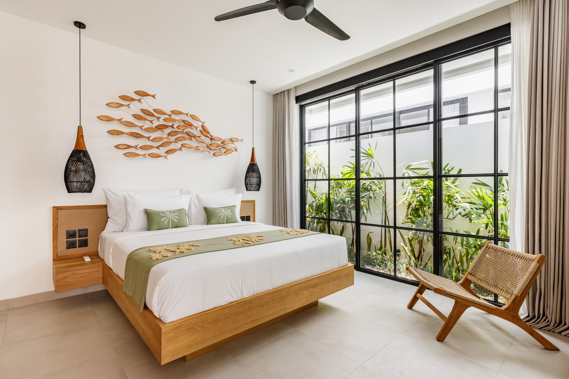 Bright bedroom with wooden bed, fish wall art, and a large window overlooking greenery