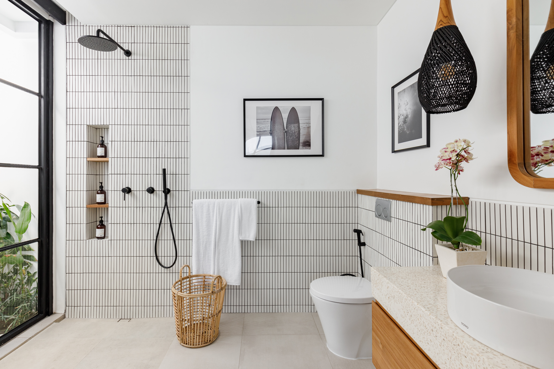 Modern bathroom with shower, tub, sink, and white tile walls with black accents