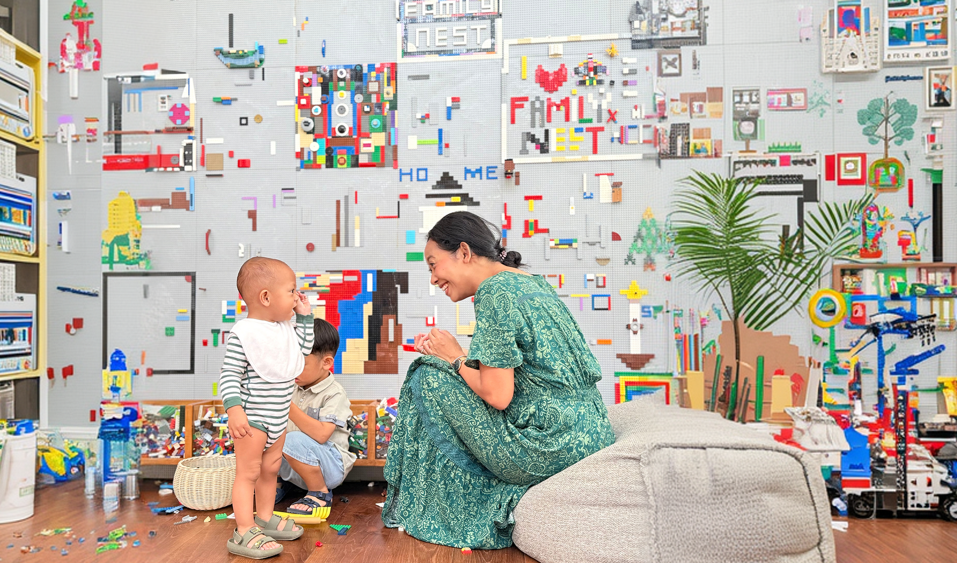 Adult and toddler playing on the floor in a colorful, toy-filled room with wall art and plants