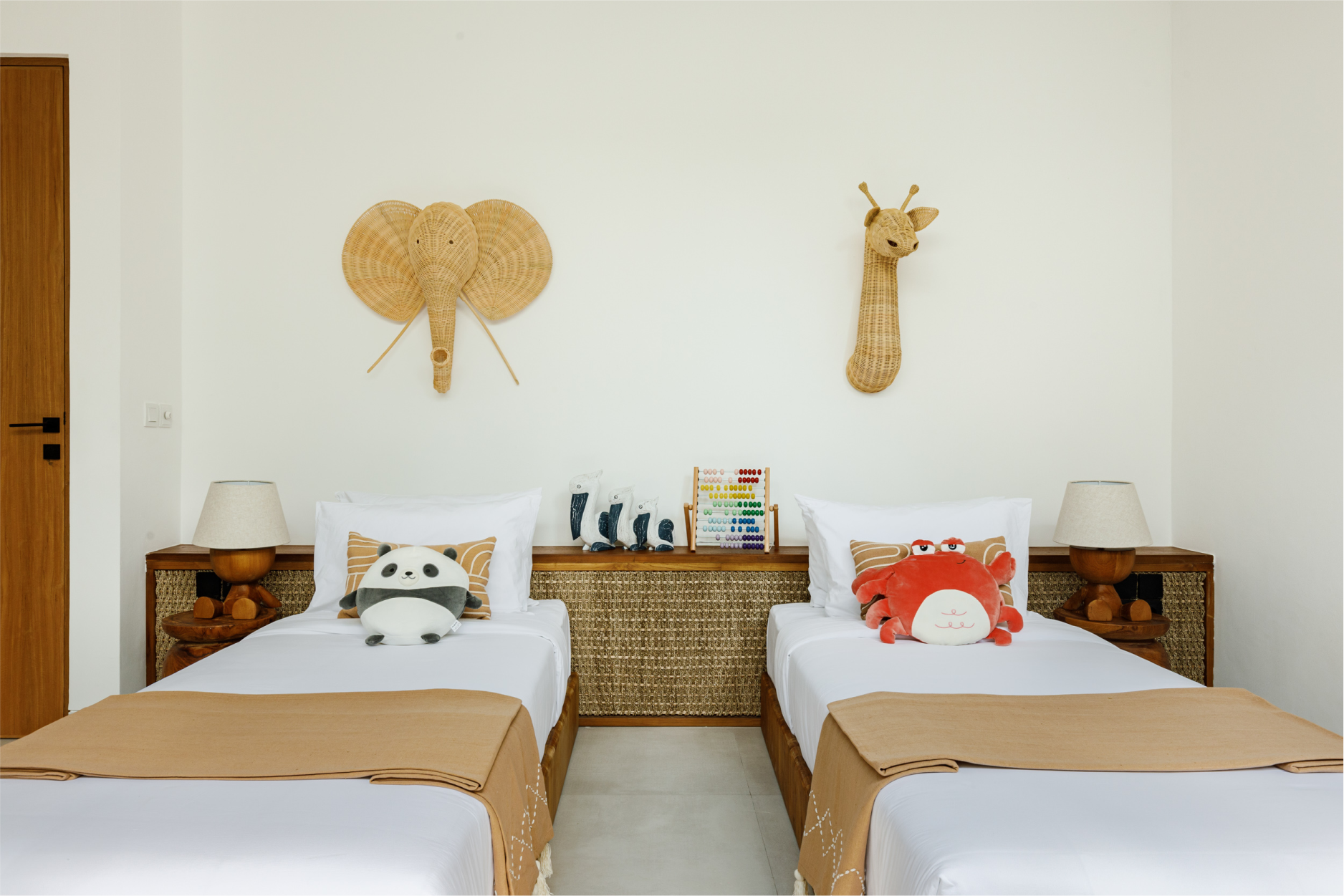 Twin beds in a cozy bedroom with animal-themed wall decor and tan bed runners