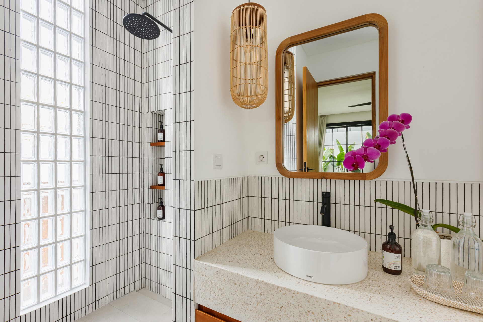 Bright bathroom vanity with mirror, white vessel sink, tiled walls, and purple orchids ליד洗?