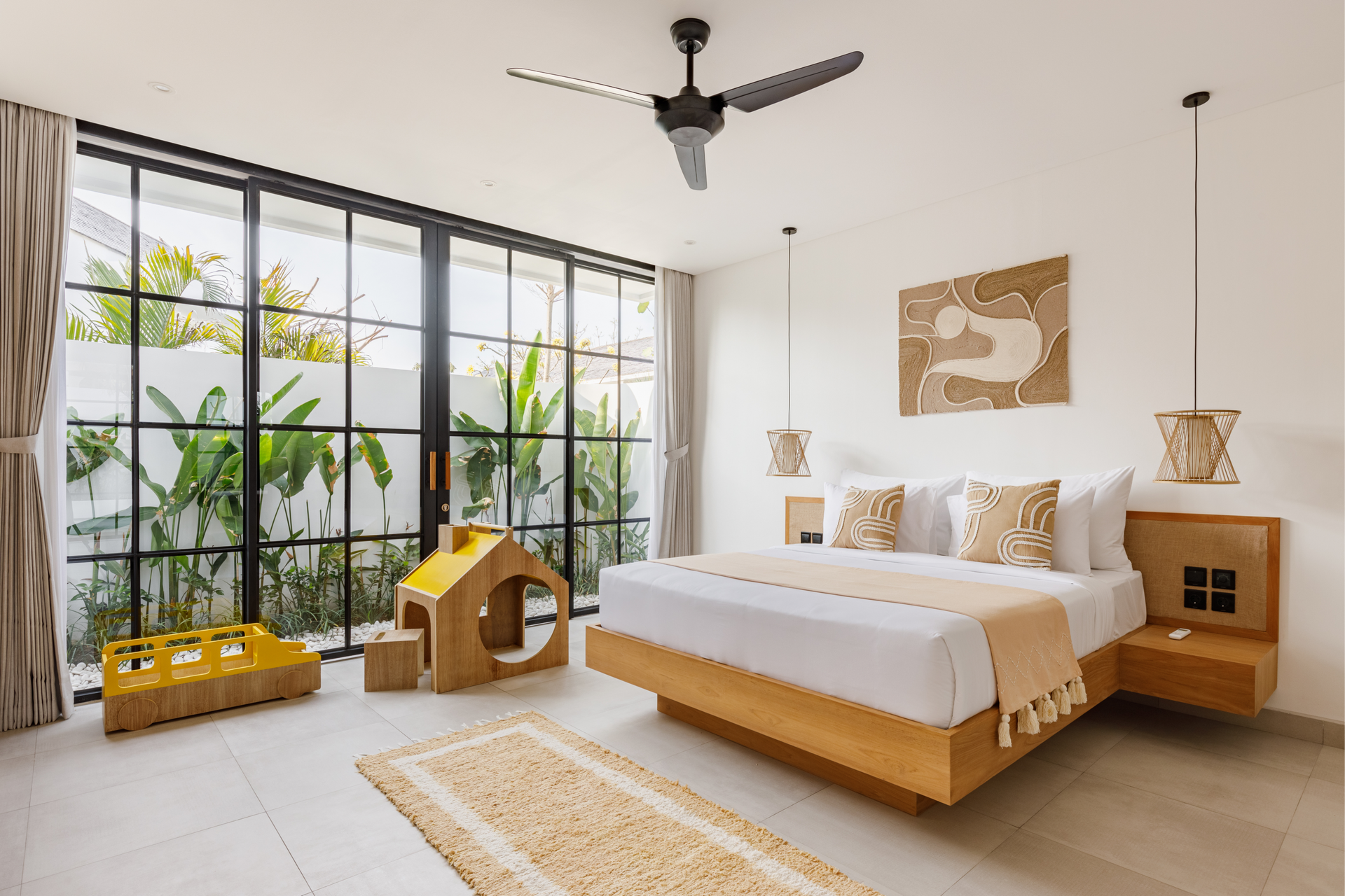 Bright minimalist bedroom with wood bed, black-framed windows, and indoor plants by a sunlit seating nook