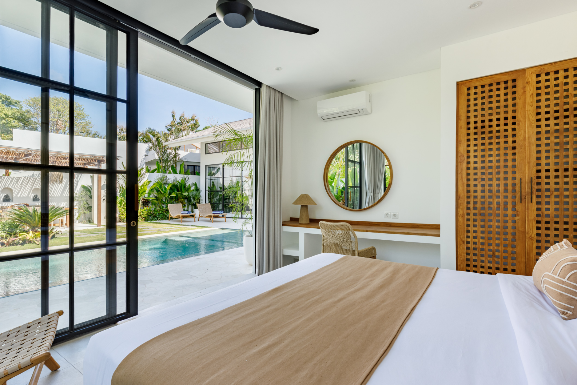 Modern bedroom with a pool view, large glass doors, and minimalist white decor
