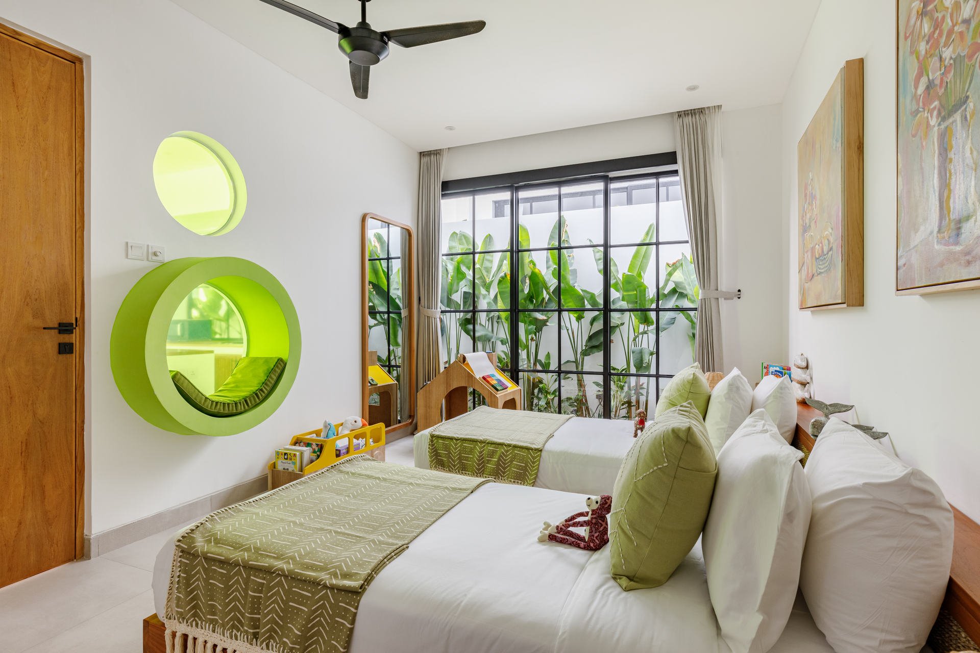 Bright bedroom with white bedding, green accents, large window, and plants by a balcony door