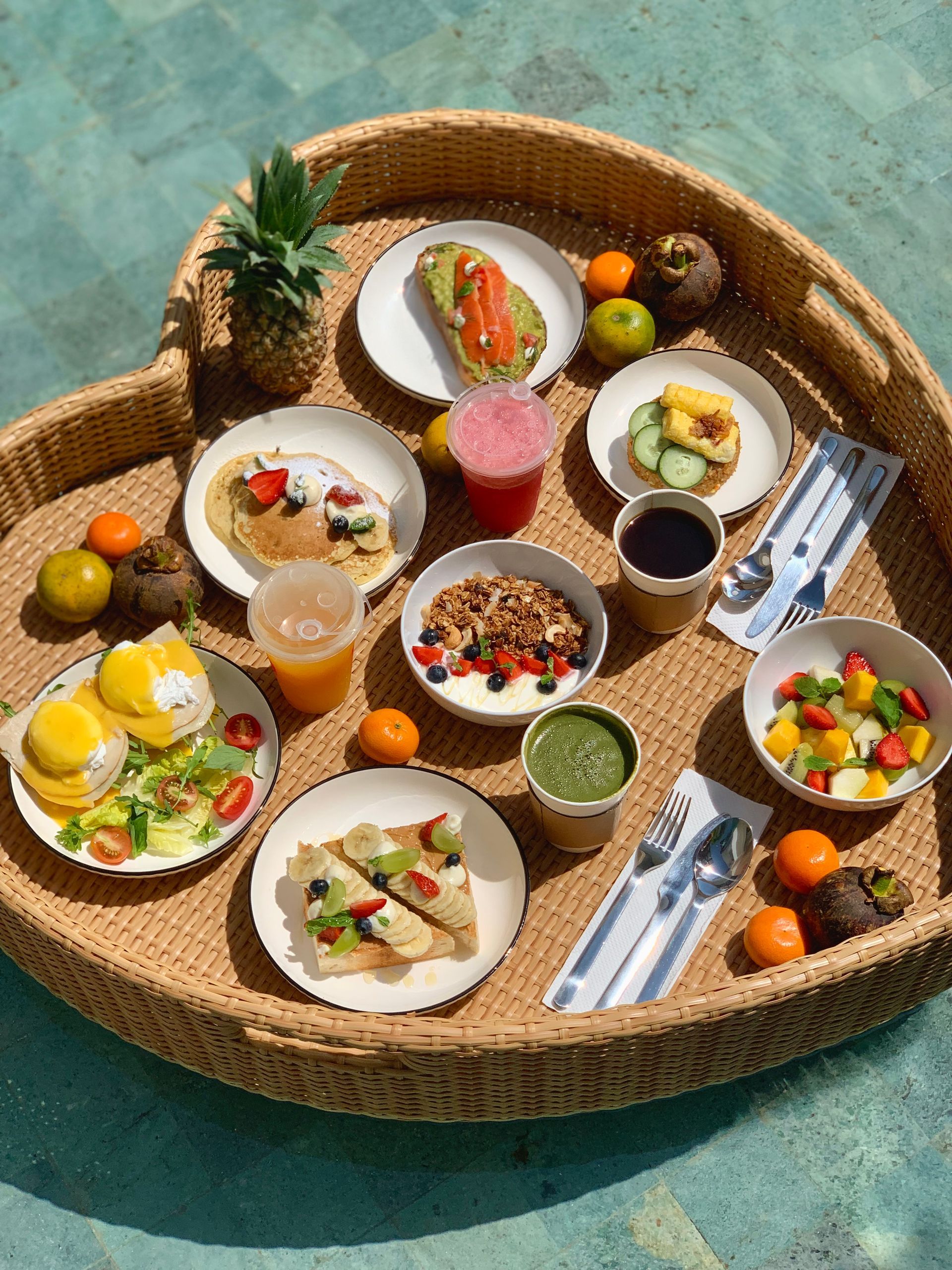 Breakfast dishes arranged on a woven tray with fruit, coffee, toast, and juice.