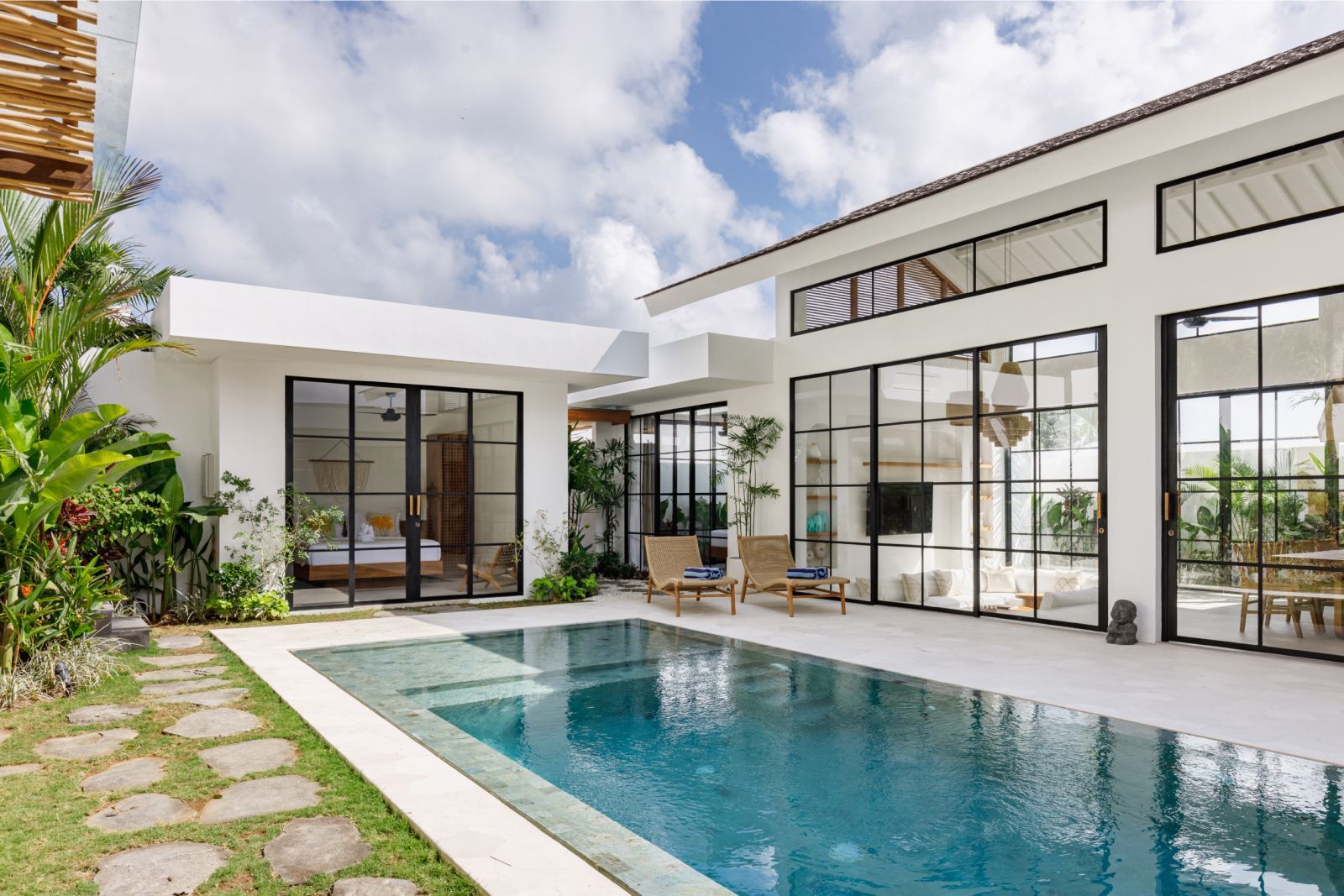 Modern house patio with a rectangular pool and large glass doors