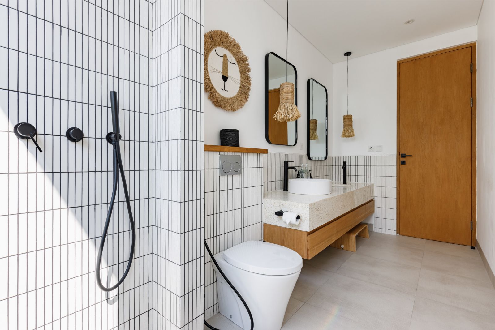 Modern bathroom with white tile walls, walk-in shower, wall-mounted sink, mirror, and wooden door