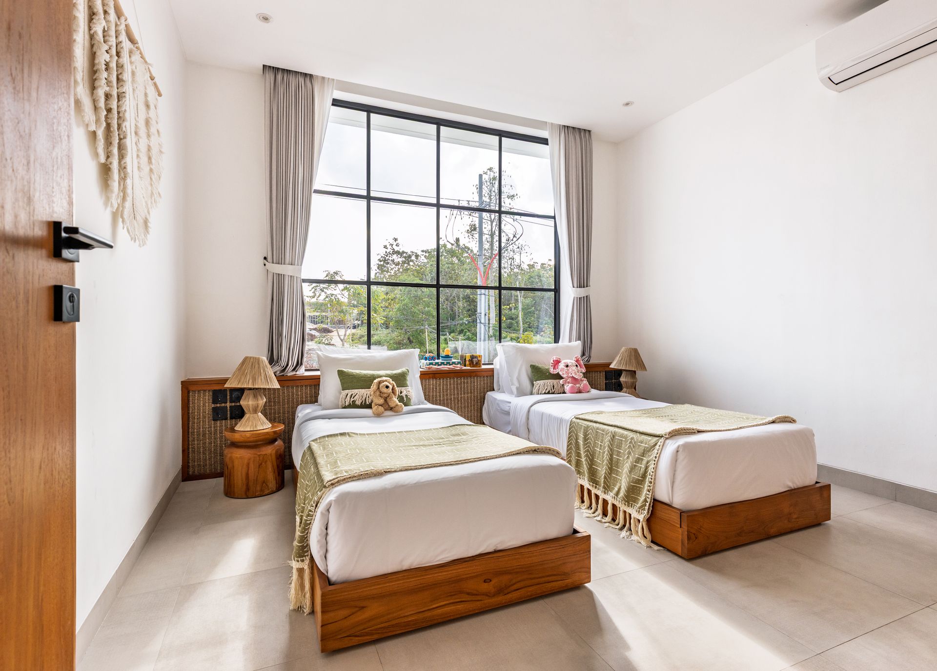 Bright twin bedroom with two beds, large window, and beige curtains in a minimalist style