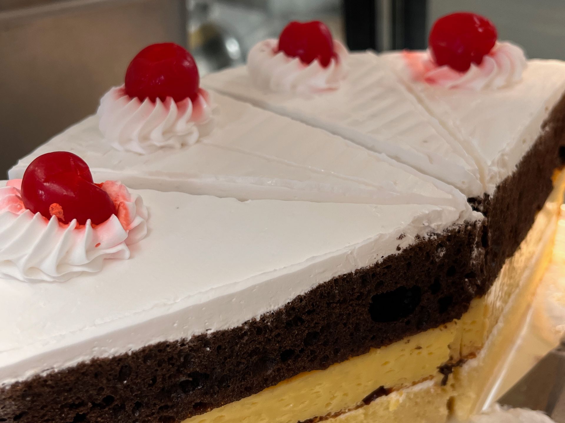 A slice of cake with whipped cream and cherries on top
