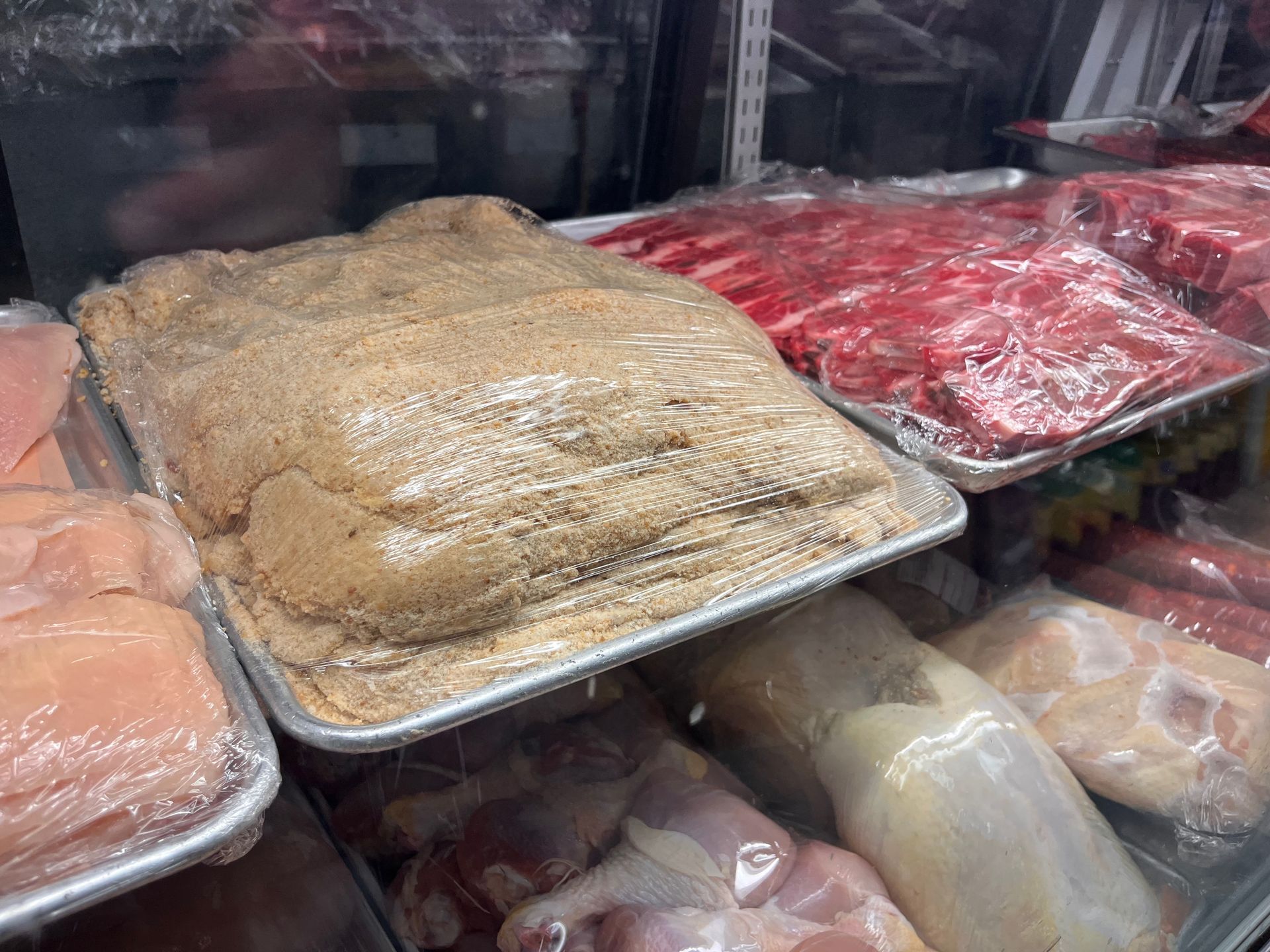 A variety of meats are on display in a butcher shop