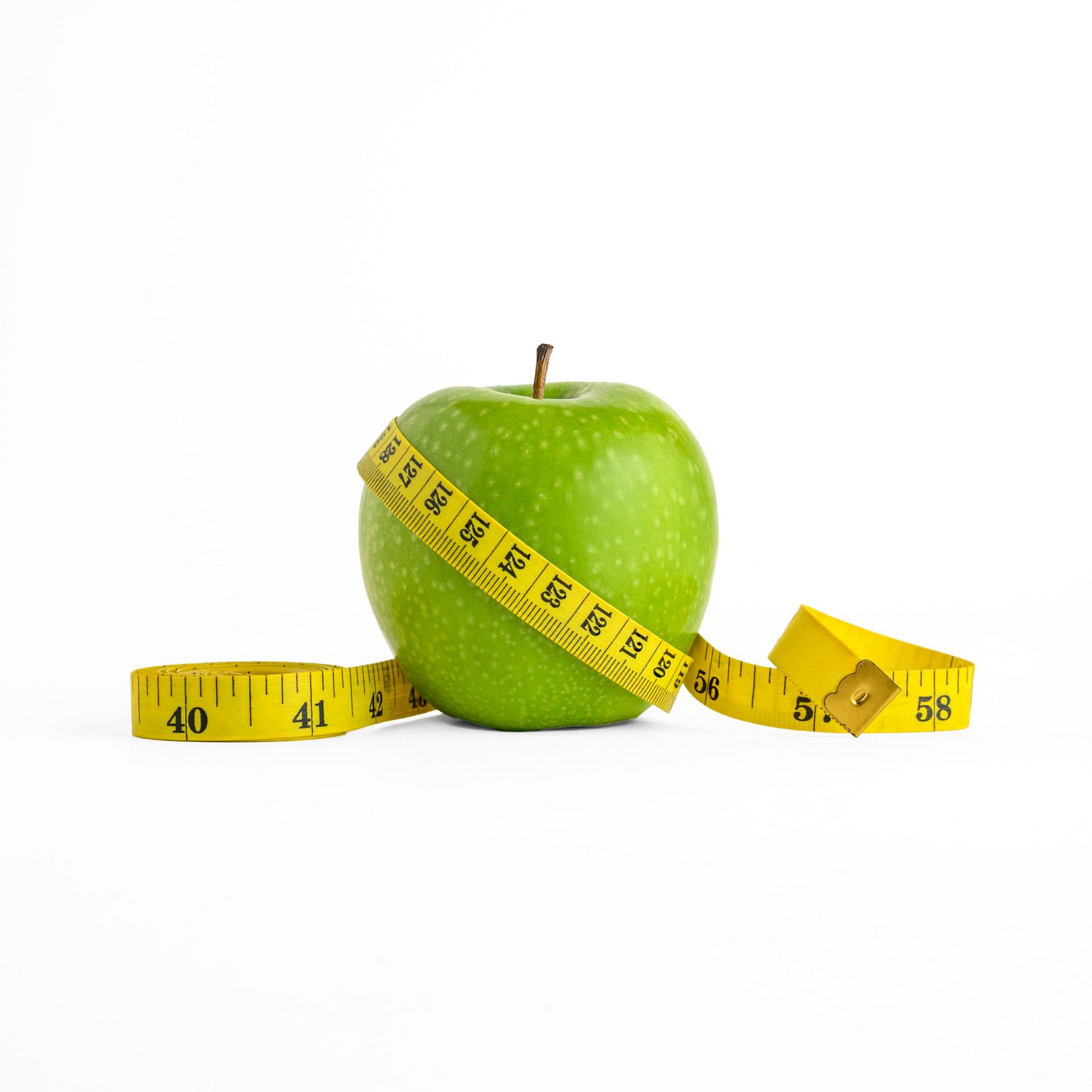 Green apple wrapped with a yellow measuring tape on a white background