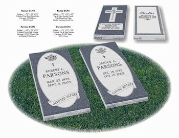 Display of four granite cemetery markers on grass, featuring oval and rectangular designs with inscriptions and symbols.