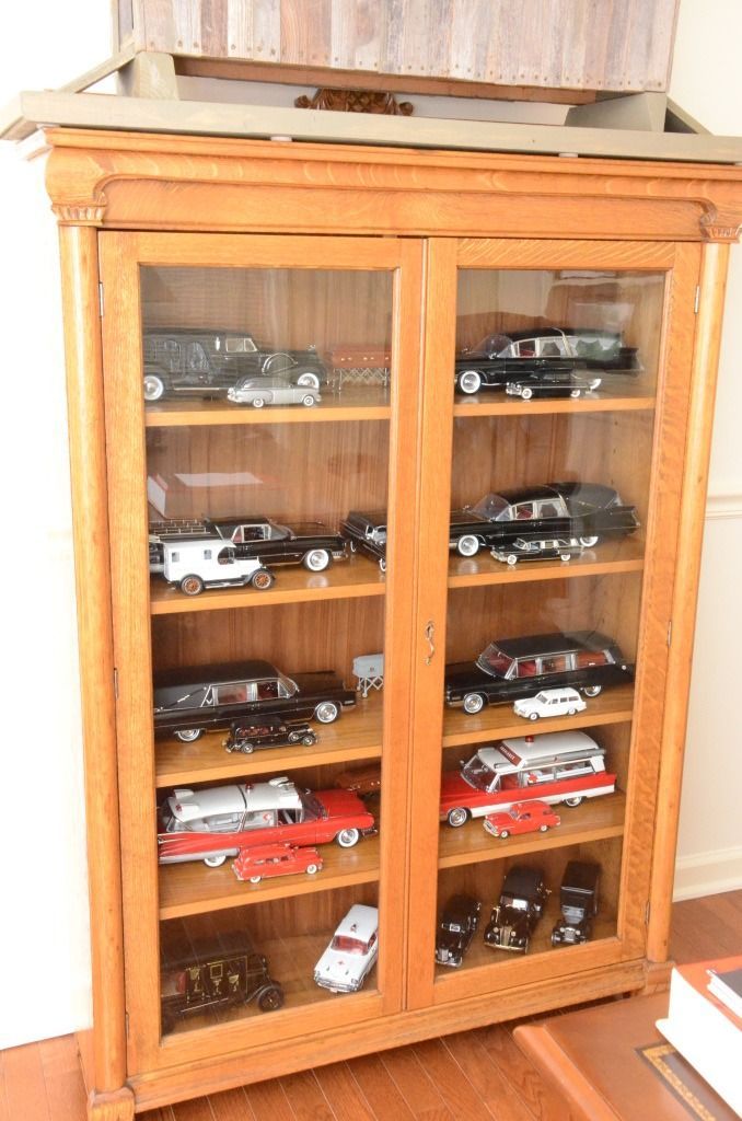 cabinet with figures of their hearses behind glass