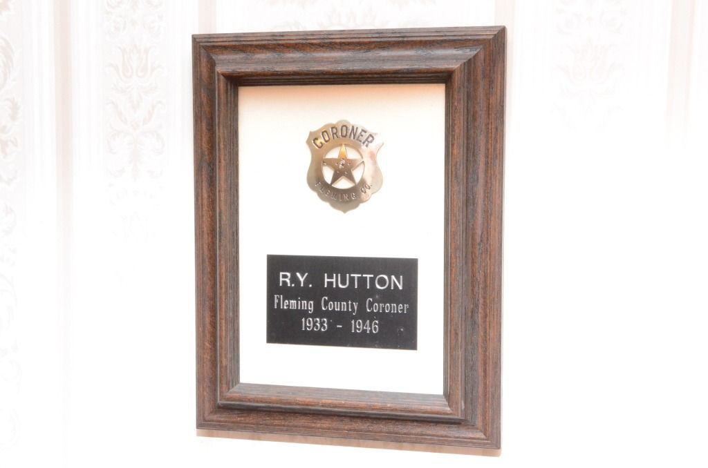 photo frame with a plaque R.Y. HUTTOM Flewing County Coroner 1933- 1946