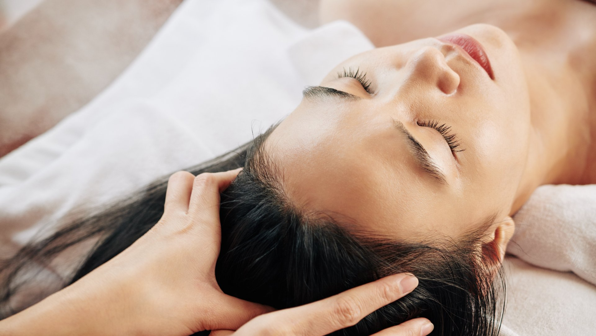 Woman with long dark hair gets a scalp massage