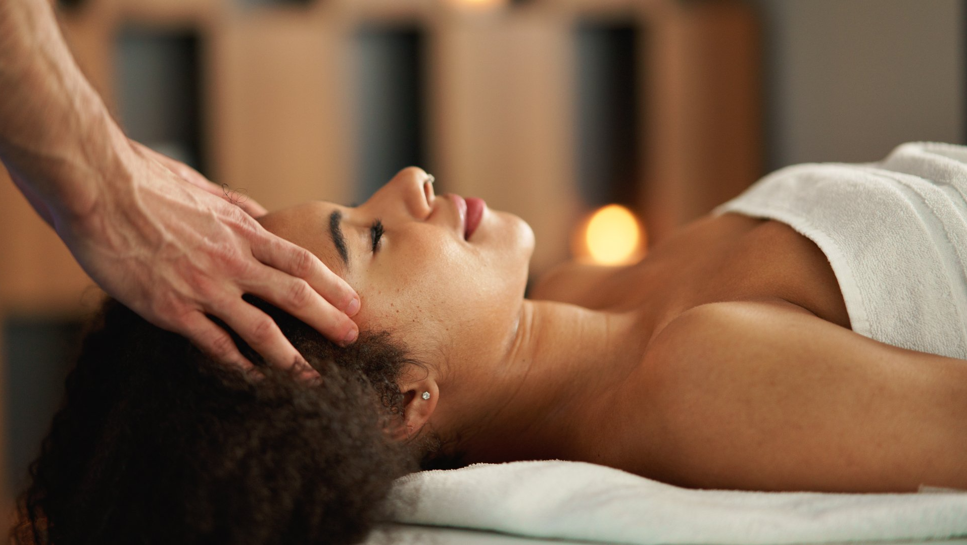 A black woman getting her temples and forehead massaged