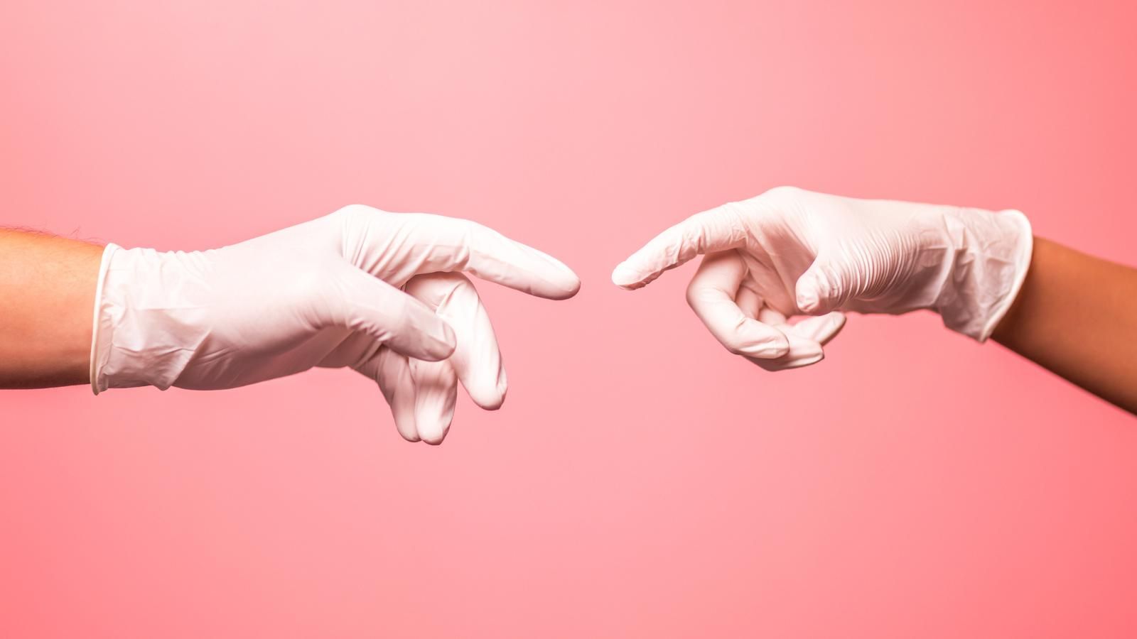 White gloved hands reaching out to touch fingers