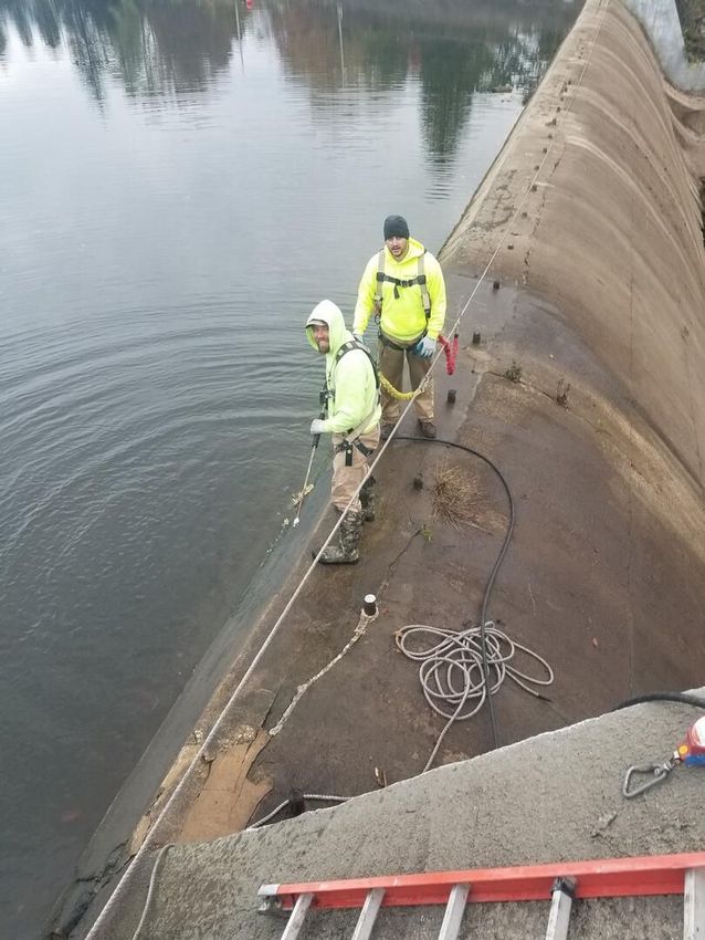 Ameriseal team members strike a pose during a job cleaning and restoring a dam