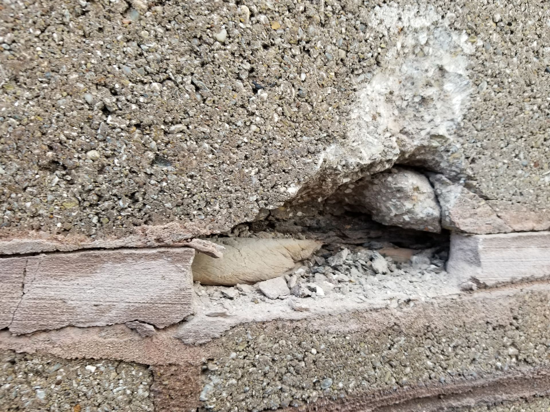 One crack in the mortar and stone block let in water leading to rust damage under the stone