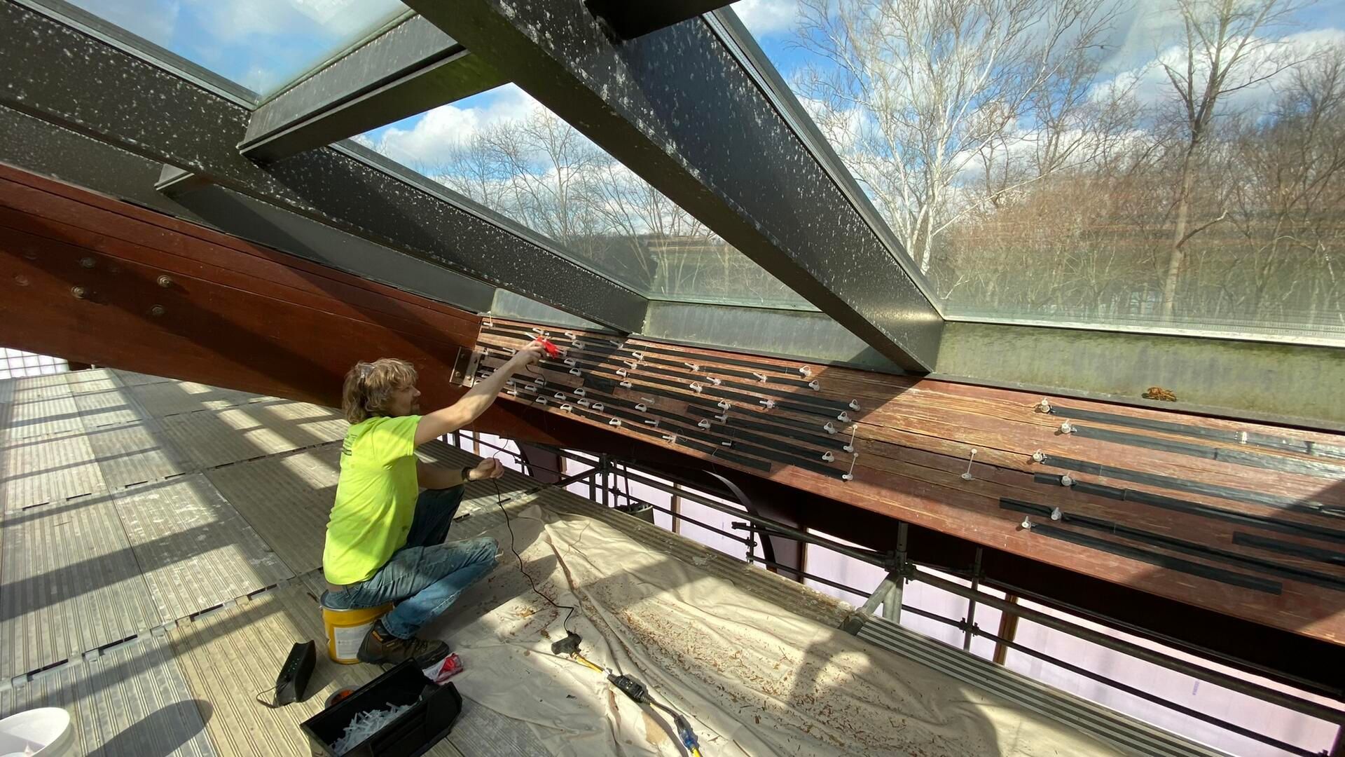 Preparing a load bearing beam for epoxy injection, ports are placed and holes are taped shut to hold epoxy in place as it hardens