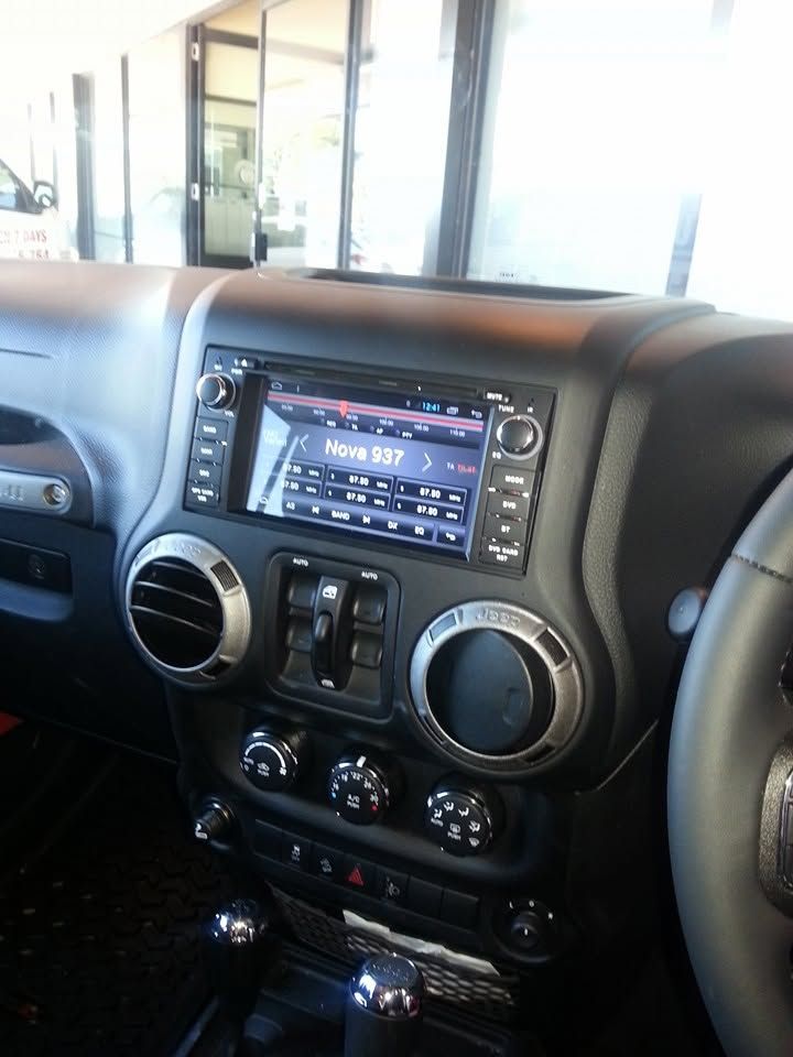 Car dashboard with touchscreen stereo, circular air vents, and climate controls in a parked vehicle. Car dashboard with touchscreen stereo, circular air vents, and climate controls in a parked vehicle.