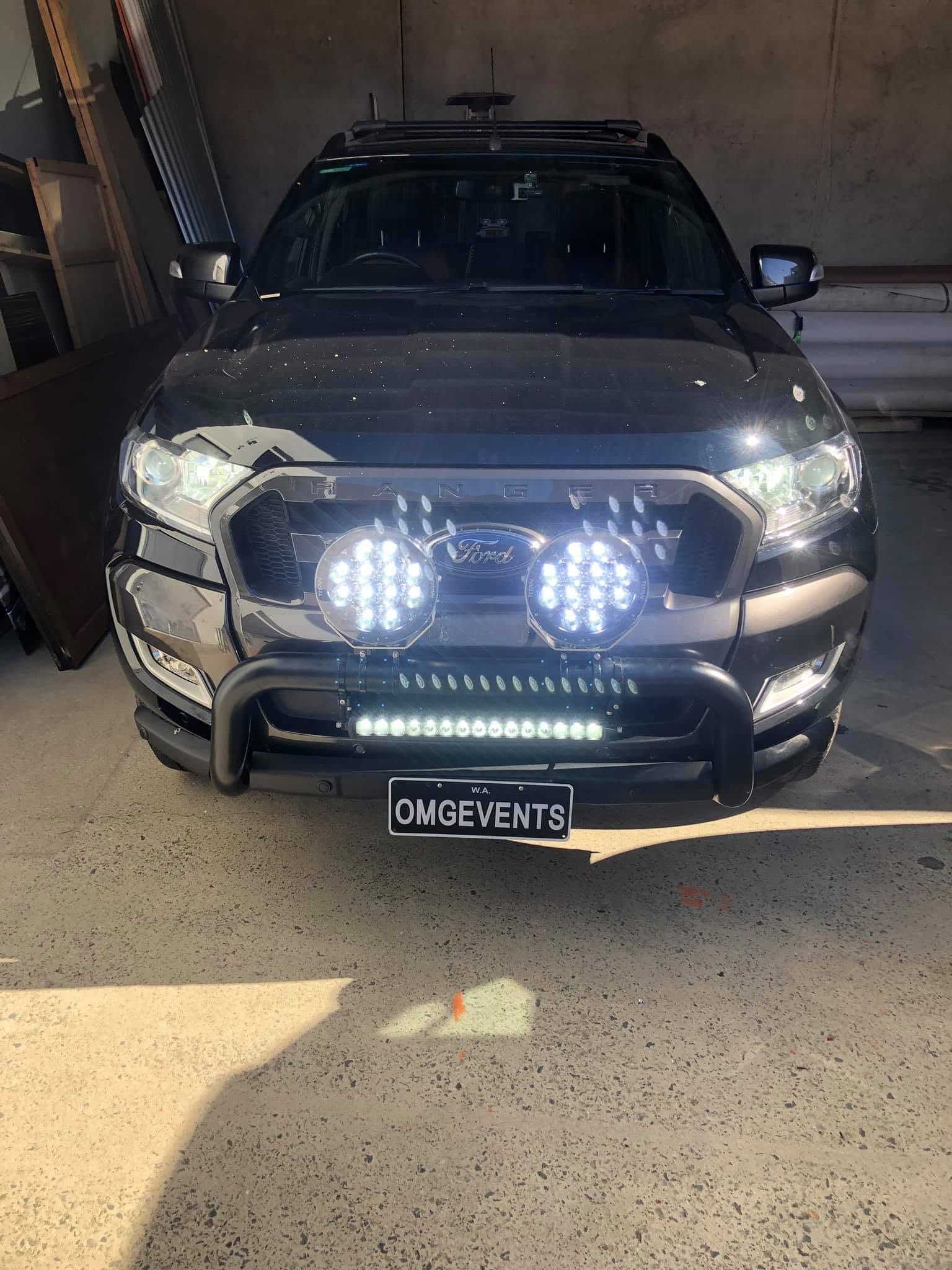 Black SUV in a garage with bright LED lights and a front bull bar. Black SUV in a garage with bright LED lights and a front bull bar.