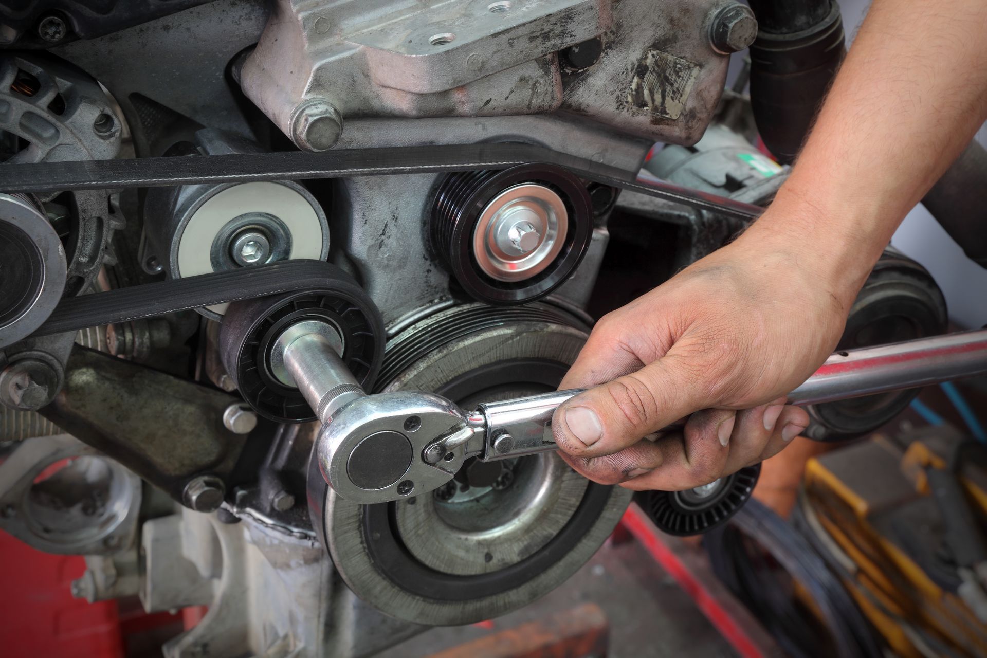 Hand tightening a bolt on a motorcycle engine with a wrench Hand tightening a bolt on a motorcycle engine with a wrench