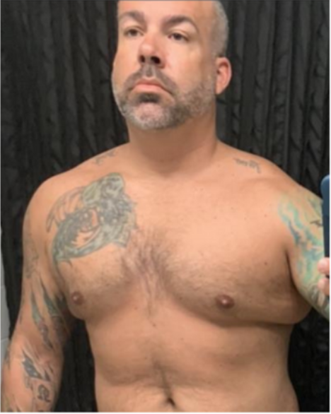 A shirtless man with tattoos on his arms and chest
