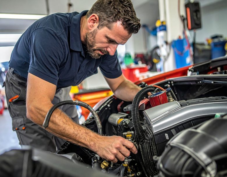 Mechanic working on a car engine, in a garage.