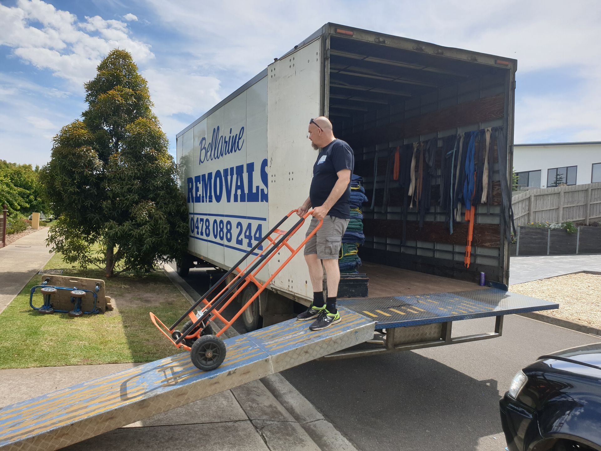 A Man is Standing On a Moving Truck — Bellarine Removals In Melton, VIC