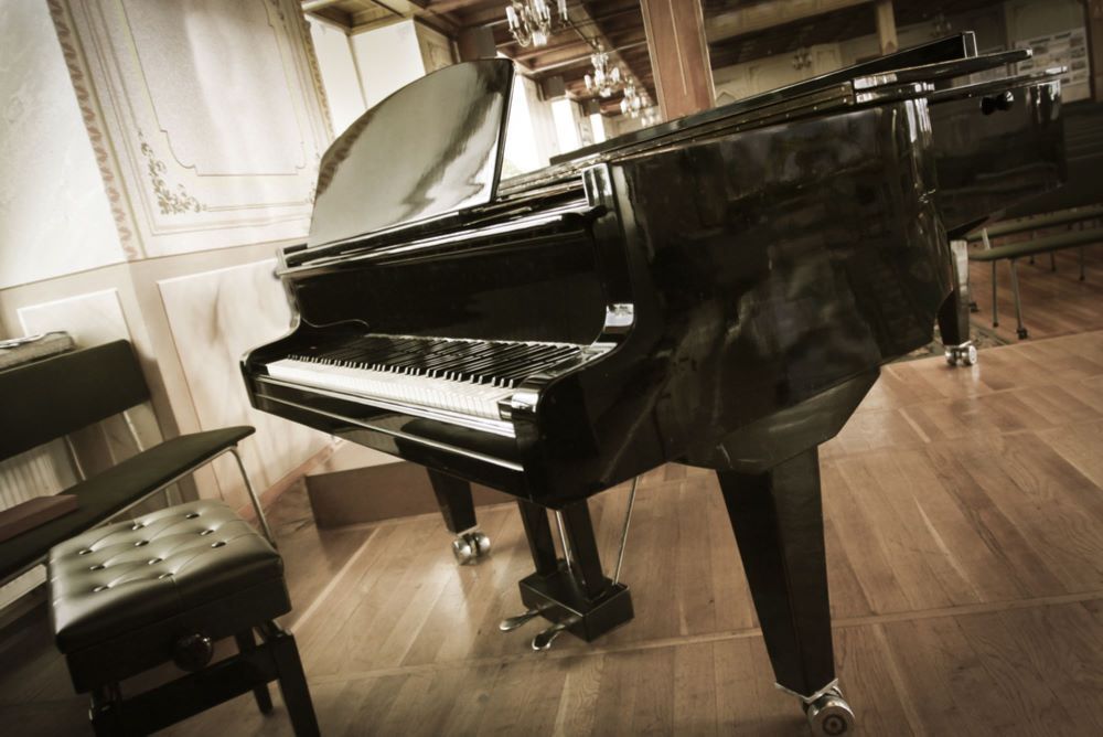 A Piano is Sitting on a Wooden Floor in a Room — Bellarine Removals In Altona, VIC