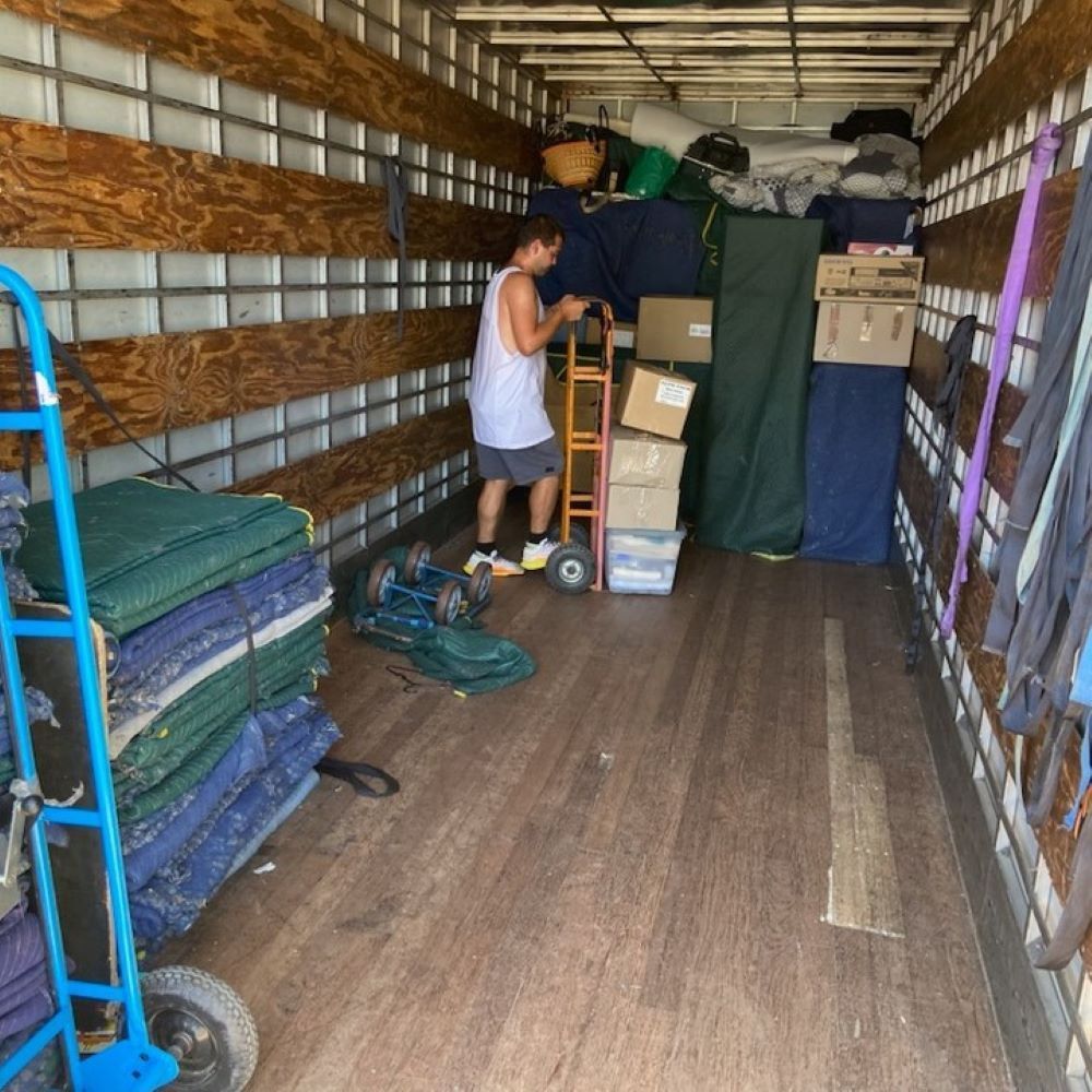 A Man is Standing in the Back of a Truck — Bellarine Removals In Altona, VIC