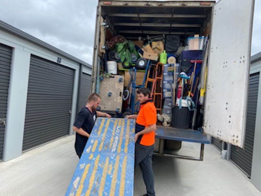 Two Men Are Loading a Truck With a Wooden Ramp — Bellarine Removals In Colac, VIC